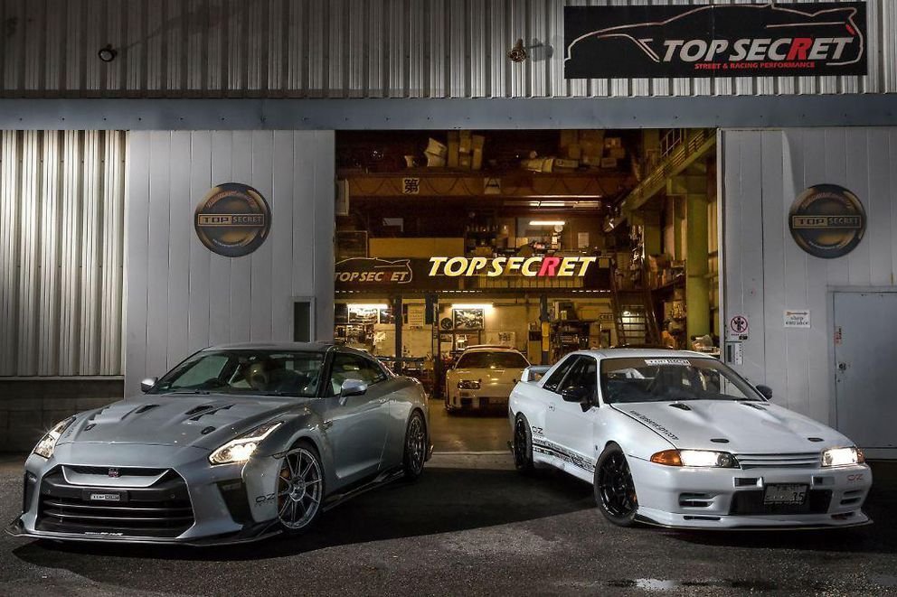 Top Secret workshop at night, two Skyline GT-Rs outside